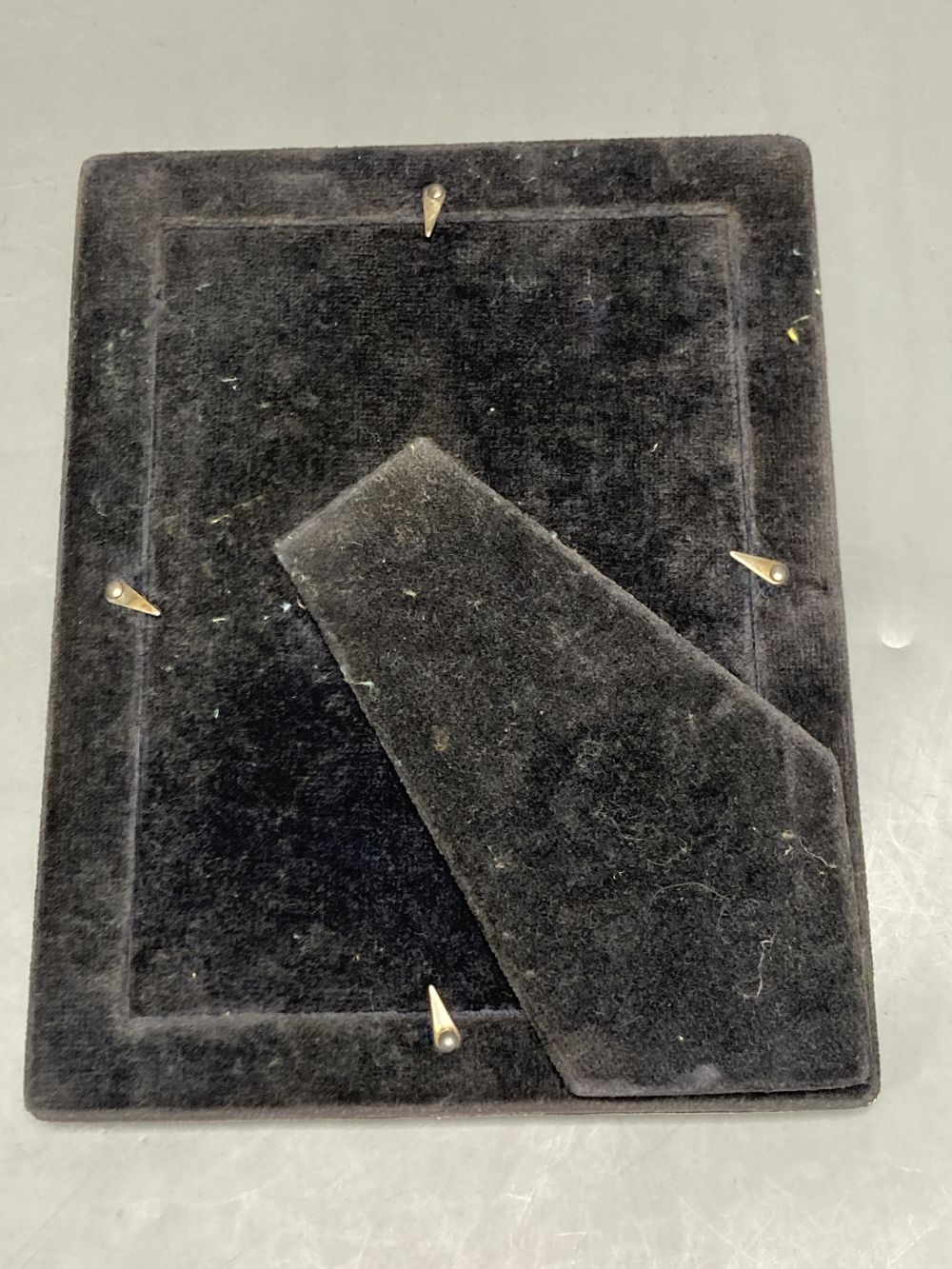 An Edwardian silver mounted photograph frame, Birmingham, 1906, 22.2cm(a.f.) and two others.